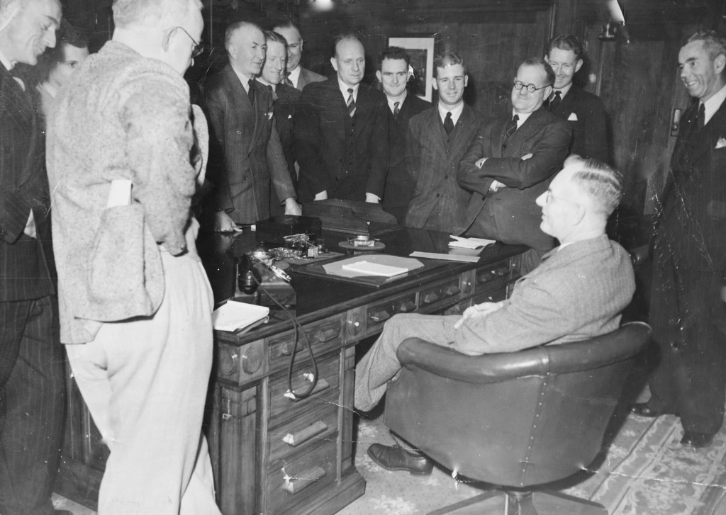 John Curtin Prime Ministerial Library. Records of the Curtin Family. Former journalist John Curtin meets the Canberra Press Gallery. (Known as The Circus) C.1945. JCPML00376/2. Curtin is seated and standing, from left to right, are Don Whitington (Daily Telegraph), Ross Gollan (Sydney Morning Herald), John Corbett (Argus), Frederick Smith (Australian United Press), Richard Hughes and Norman Kearsley (Brisbane Telegraph), T L Thomas (Australian United Press), Ted Waterman and Joe Alexander (Melbourne Herald), Jack Commins (Australian Broadcasting Commission) and Don Rodgers (Curtin's press secretary). This copy courtesy of the Reid family collection.